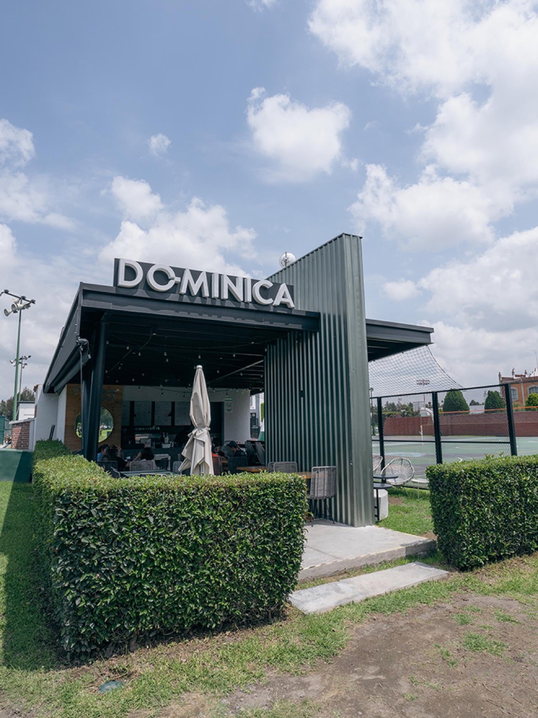 Módulo verde de Dominica 19 en el campus UDLAP, rodeado de setos
